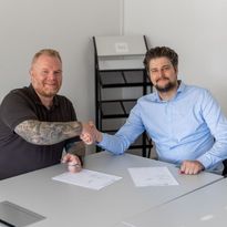 Shaking hands next to the signed contract