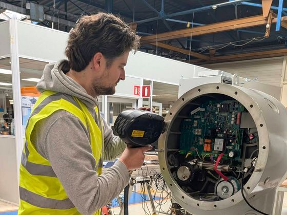 Metal Spark technician performing an on-site OES PMI analysis on an industrial housing with the spark probe of a mobile Spectroport spectrometer